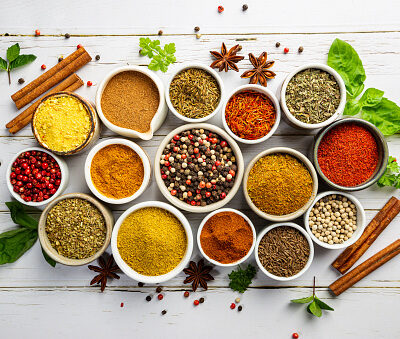 Herbs and spices in bowels over white wooden background. Top view with copy space